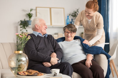 caregiver and senior couple smiling