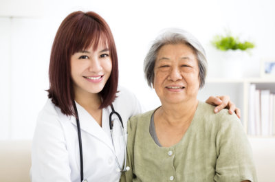 nurse with stethoscope and senior woman smiling